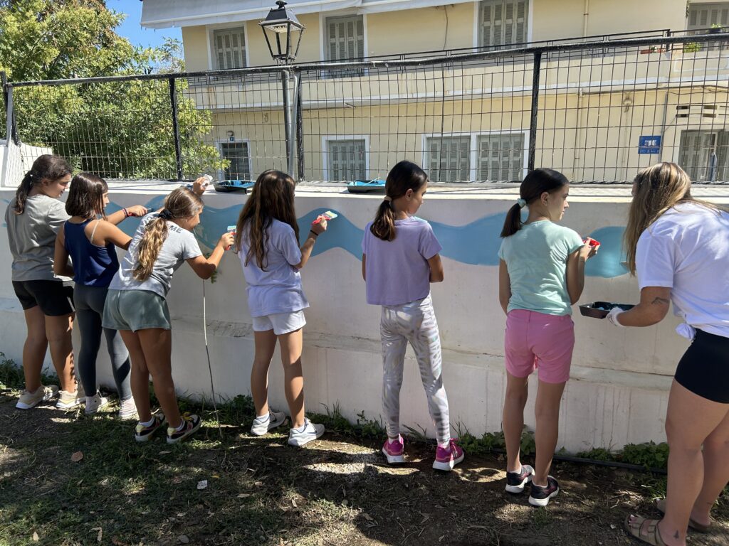 Volunteers work together on a wall painting in Chania.