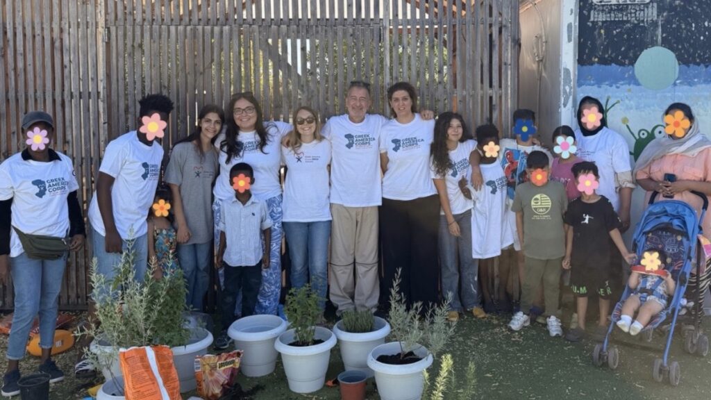 Greek America Corps participants and children gathered beside potted herbs on Chios in summer 2026.