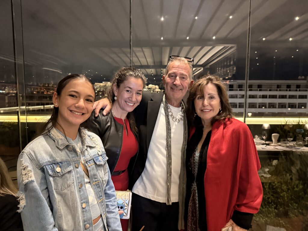 Gregory Pappas and three guests smiling together at the dinner.