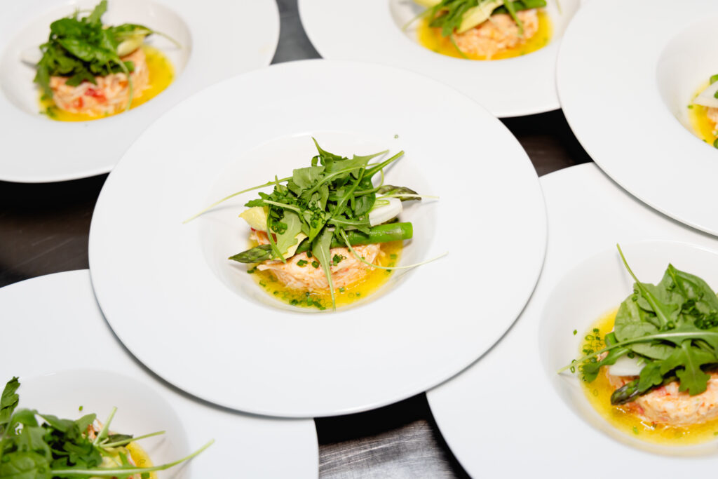 Plated food topped with fresh green leaves, ready for service.