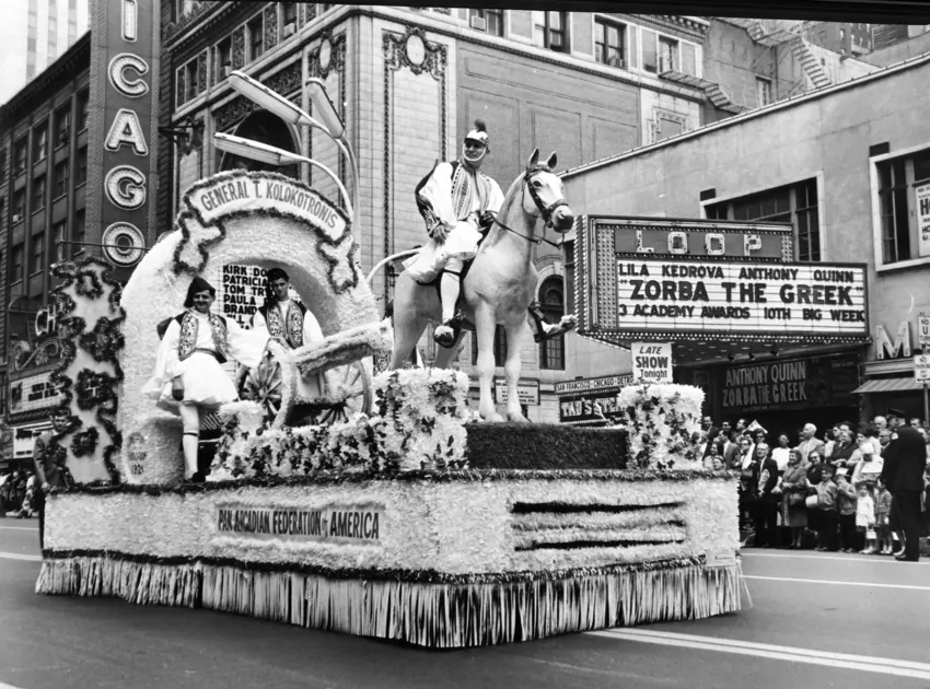 A decorated parade float passing city theaters