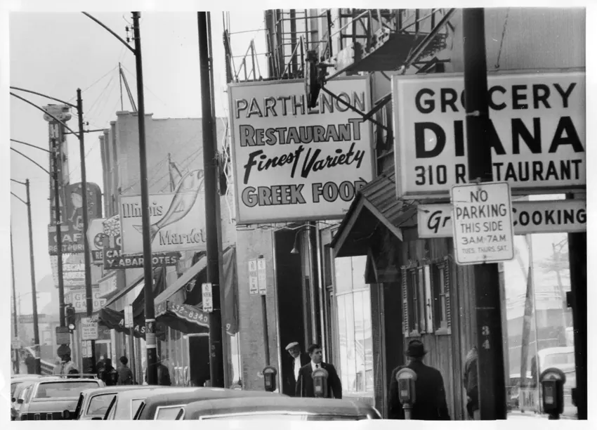 Greek restaurant and grocery signs along a neighborhood street